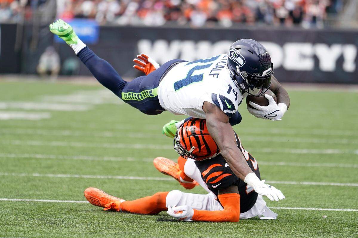 Seattle Seahawks wide receiver DK Metcalf (14) dives over Cincinnati Bengals’ Cam Taylor-Britt (29) for a first down during the second half of an NFL football game, Sunday, Oct. 15, 2023, in Cincinnati. (AP Photo/Michael Conroy)