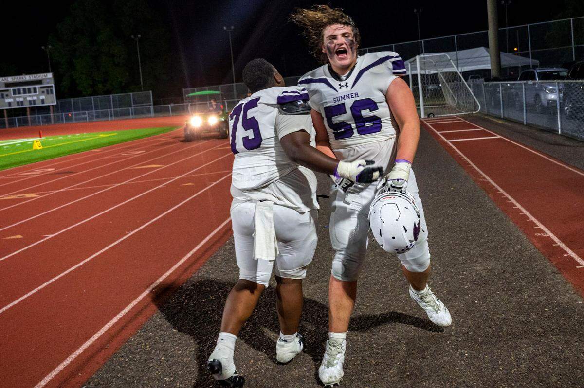 Sumner’s Rayvoughn “Bubba” Varnado (75) and Dylan Sikorsky celebrate as the leave the field after beating Puyallup, 40-10, in a A SPSL game on Friday, Sept. 23, 2022, at Sparks Stadium in Puyallup, Wash.