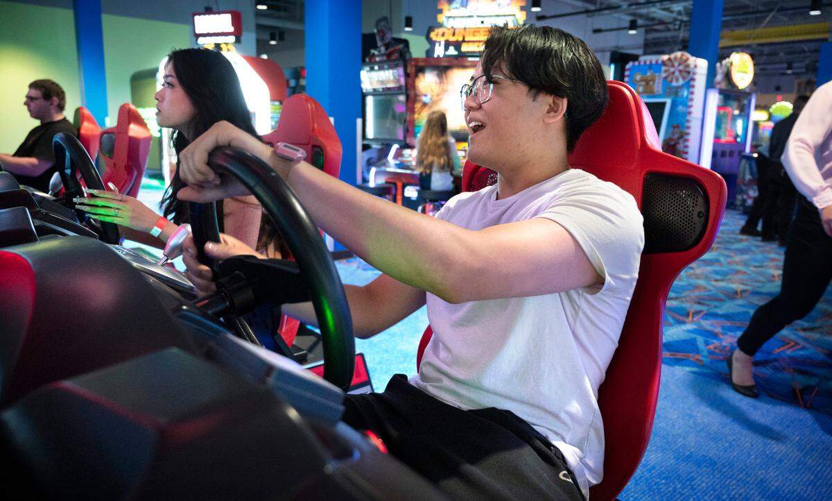Ivana Que (left) and Jin Wu of Puyallup battle in a car race on the “Maximum Tune 5DX” driving video game during a family & friends soft opening of the Round 1 entertainment venue at the South Hill Mall in Puyallup, Washington on Friday, Aug. 12, 2022.
