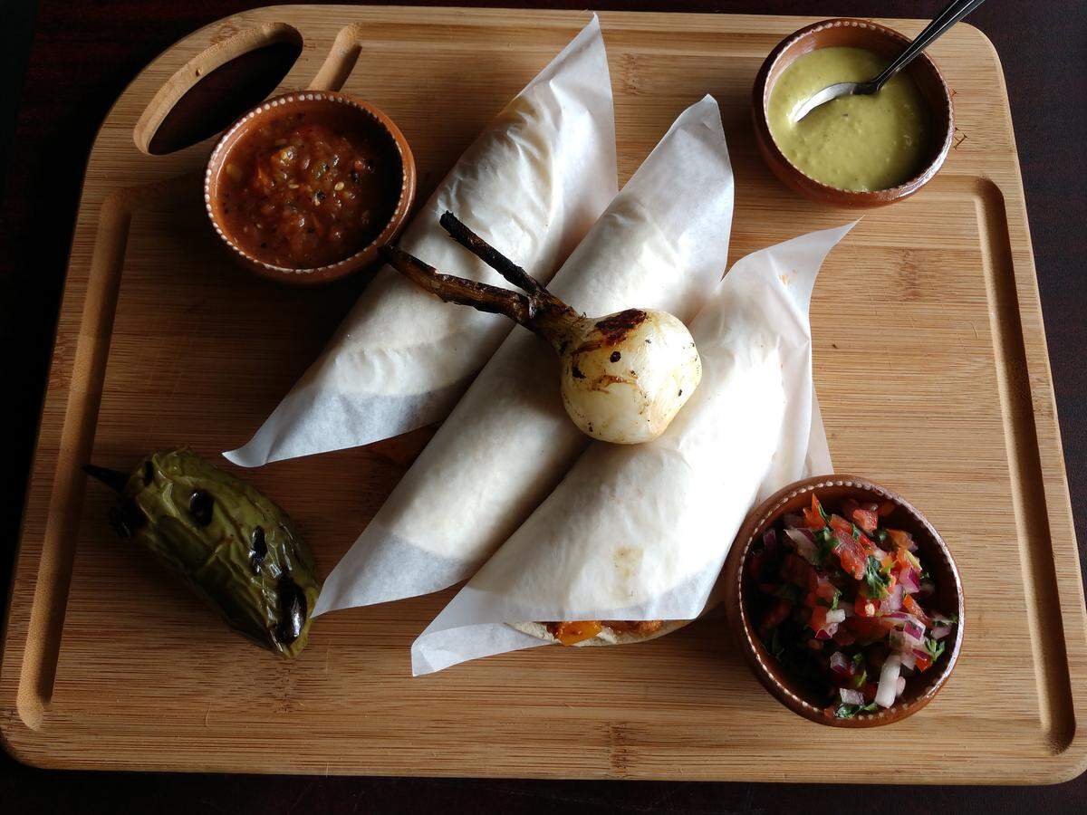 A trio of al pastor street tacos from Ta Carbon.