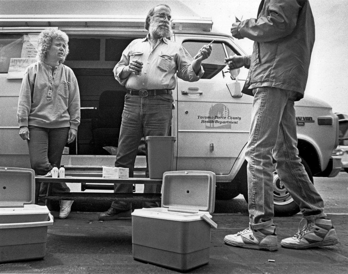 Dave Purchase hands fresh hypodermic needles to a client at the free needle exchange in downtown Tacoma, June 5, 1990.