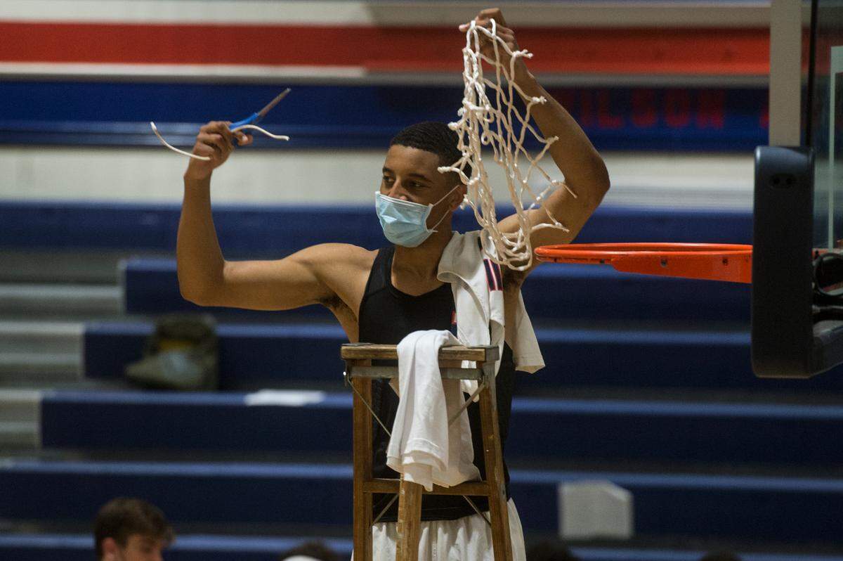 Wilson High School guard Cayden McDaniel holds up the net following the Class 3A Pierce County League boys basketball championship win over Spanaway Lake on Saturday, June 12, 2021 at Wilson High School in Tacoma, Wash.