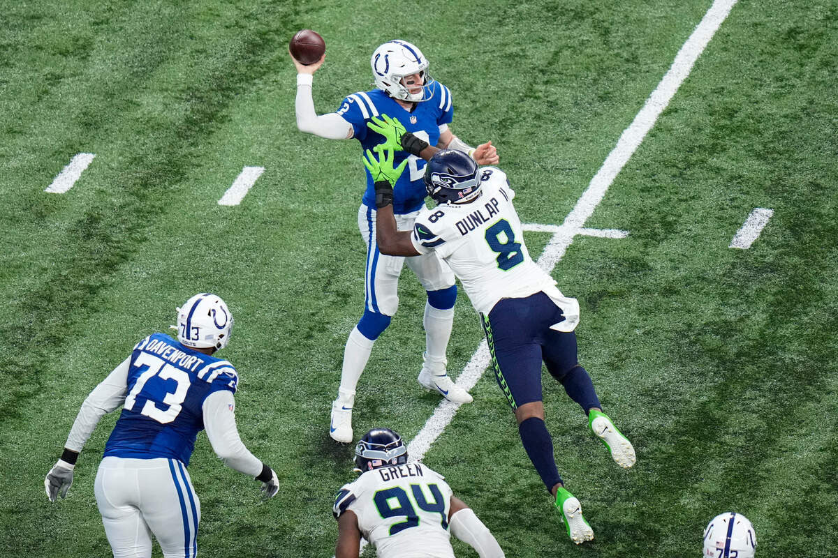 Indianapolis Colts quarterback Carson Wentz (2) is pressured by Seattle Seahawks defensive end Carlos Dunlap (8) during the second half of an NFL football game in Indianapolis, Sunday, Sept. 12, 2021. (AP Photo/AJ Mast)