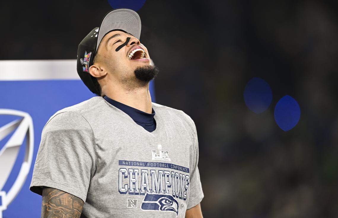 Seattle Seahawks wide receiver Jaxon Smith-Njigba (11) yells from the stage while accepting the George Halas Trophy after winning the NFC Championship game against the Los Angeles Rams at Lumen Field, on Sunday, Jan. 25, 2026, in Seattle.