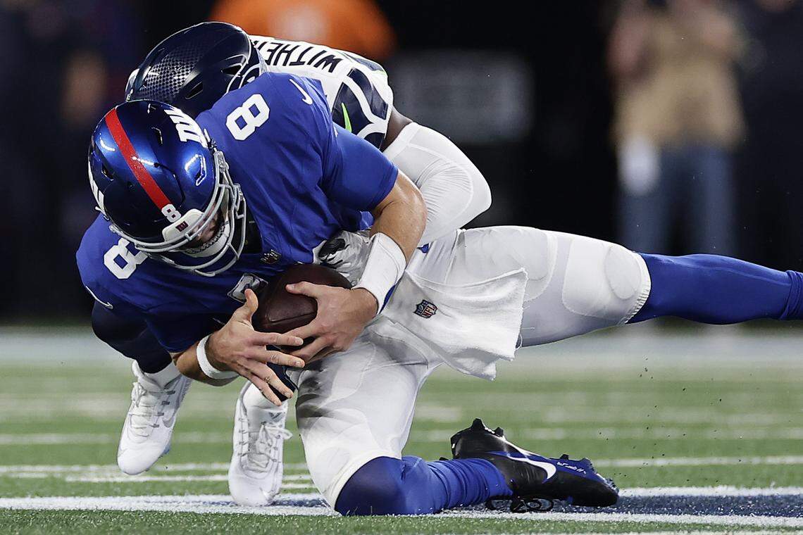 New York Giants quarterback Daniel Jones (8) is sacked by Seattle Seahawks cornerback Devon Witherspoon (21) during the first quarter of an NFL football game, Monday, Oct. 2, 2023, in East Rutherford, N.J. (AP Photo/Adam Hunger)