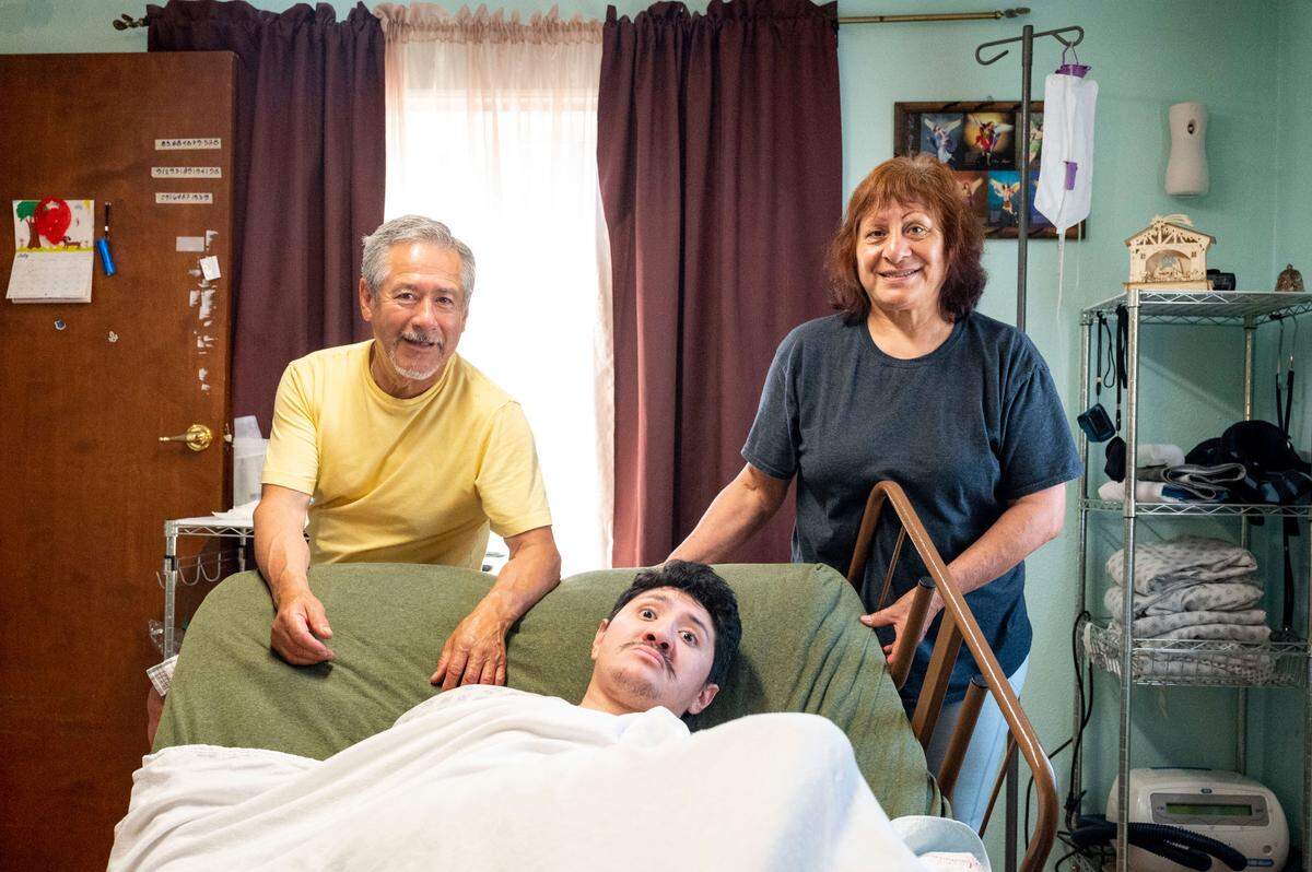 Armando Aragon and his wife, Maria Gonzalez, pose for a portrait with their son, Brian Aragon, at their home in Meridian Estates on Tuesday, July, 26, 2022, in Puyallup, Wash.