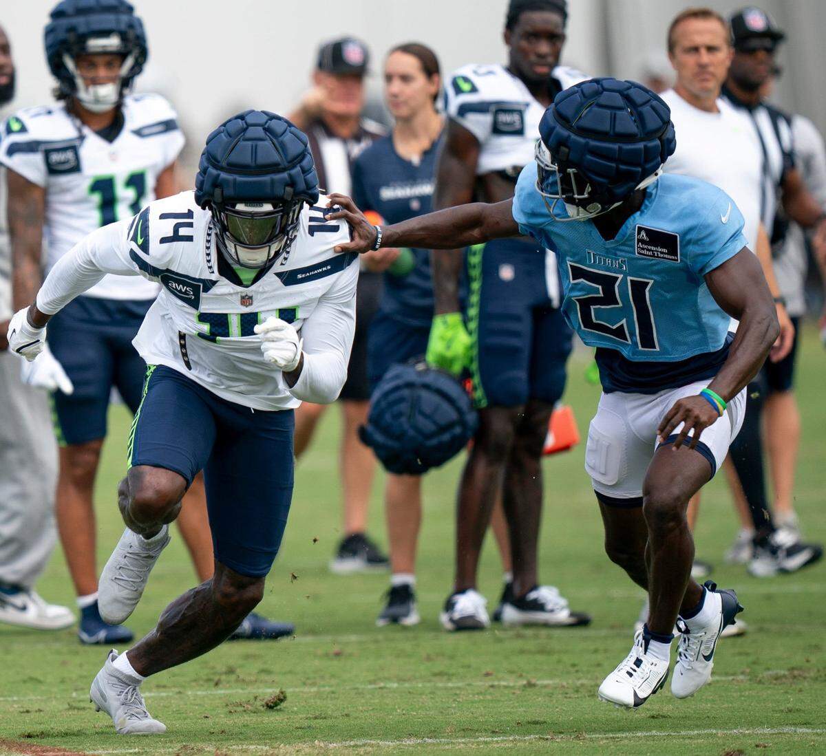 Seattle Seahawks wide receiver DK Metcalf (14) and Tennessee Titans cornerback Roger McCreary (21) compete at Ascension Saint Thomas Sports Park in Nashville, Tenn., Wednesday, Aug. 14 2024. This is the first day of the Titans joint practice with the Seattle Seahawks.