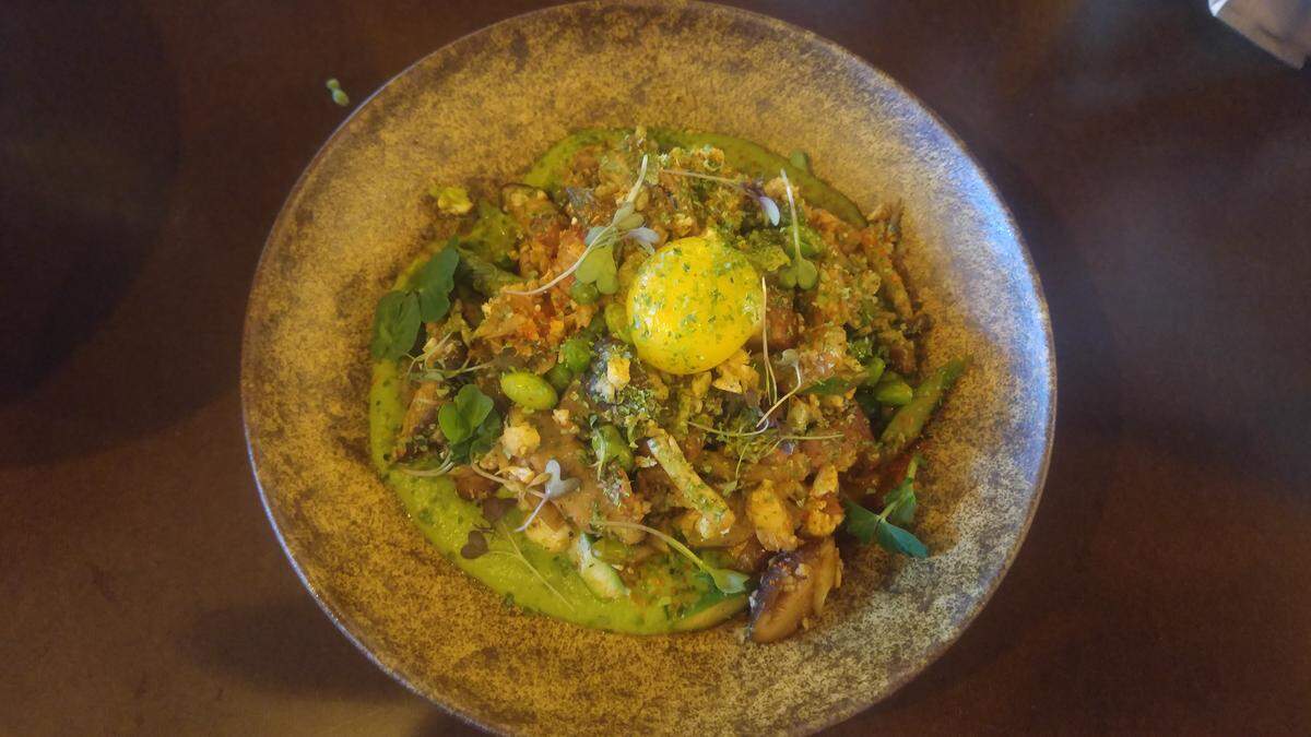 A bowl of riced cauliflower with a raw egg yolk and bacon from Moshi Moshi, a ramen restaurant in Tacoma's Stadium neighborhood.
