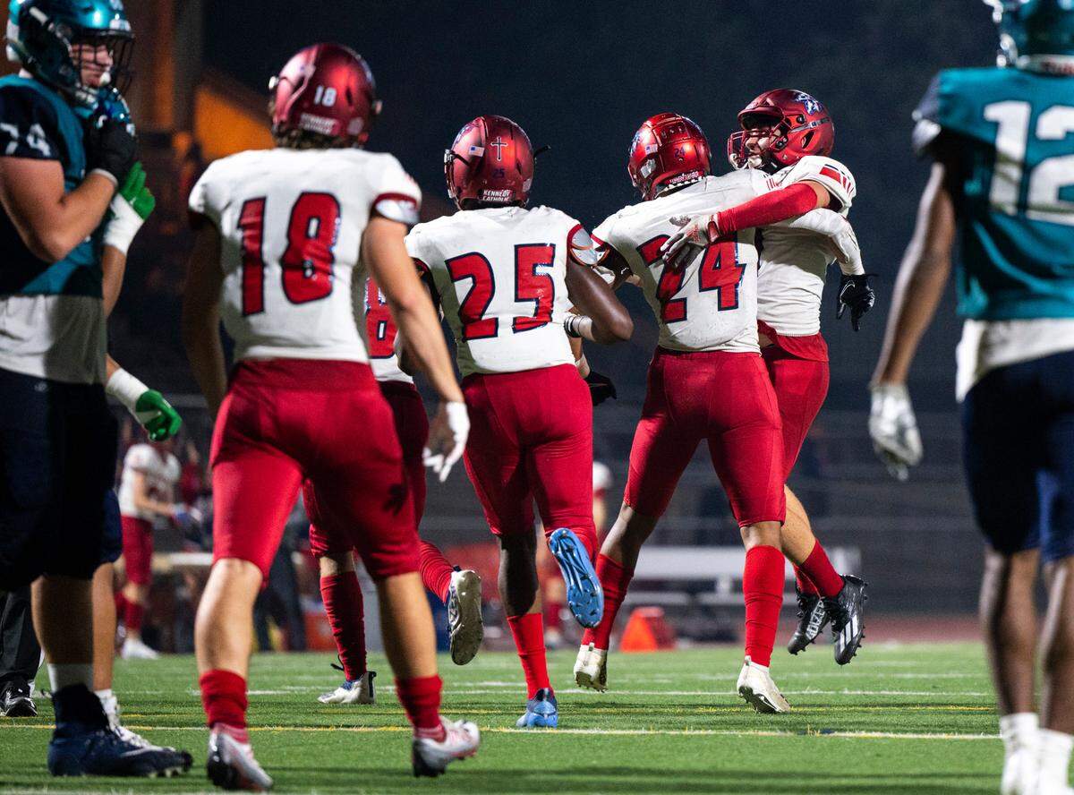 Kennedy Catholic linebacker Xe’Ree Alexander (24) and linebacker Thomas Bevilacqua (11) celebrate after defending against Auburn Riverside and stopping them from scoring a touchdown near the end zone in the fourth quarter of a game at Auburn Memorial Stadium in Auburn, Wash. on Oct. 6, 2022. Kennedy Catholic defeated Auburn Riverside 47-17.