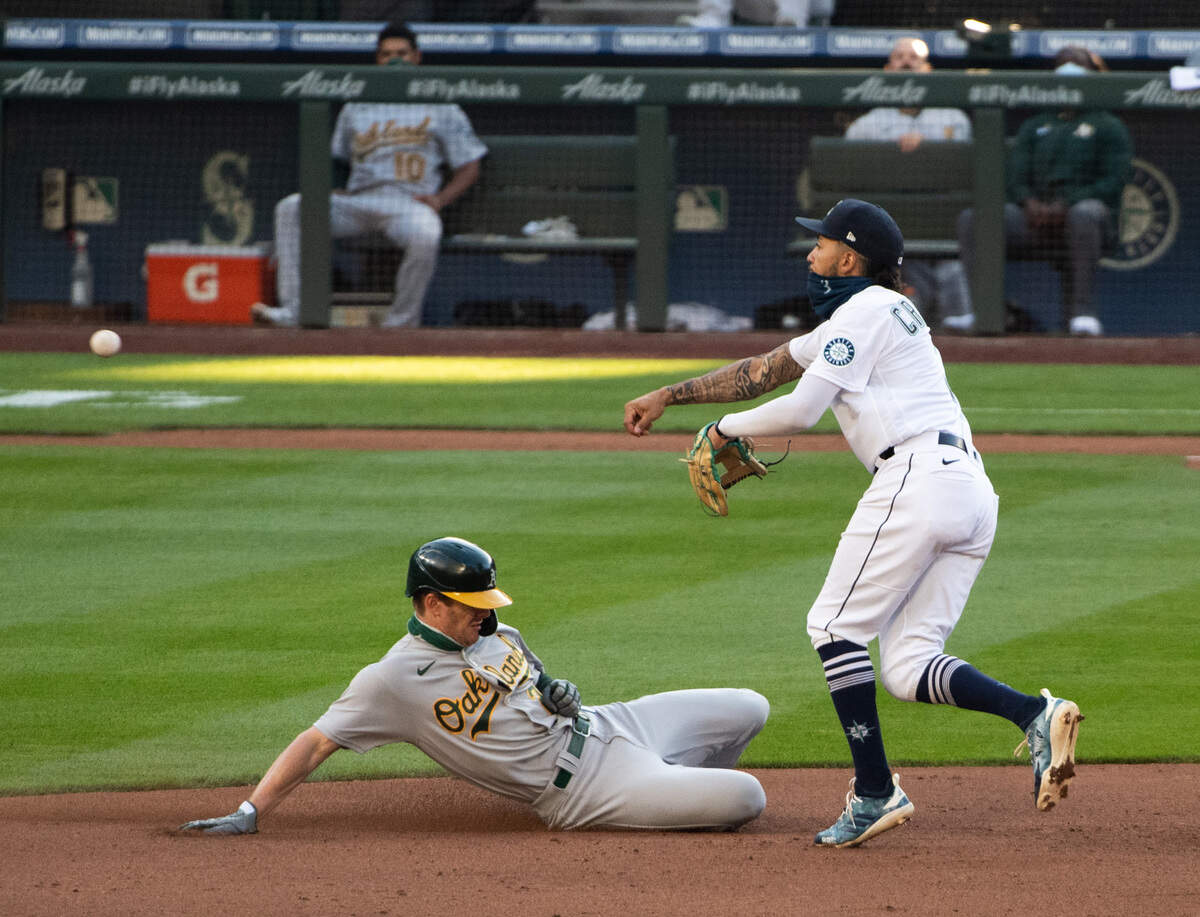 Seattle Mariners J.P. Crawford turns a double play in the fourth inning. The Seattle Mariners played the Oakland Athletics in a Major League Baseball game at T-Mobile Park in Seattle, Wash., on Saturday, Aug. 1, 2020.