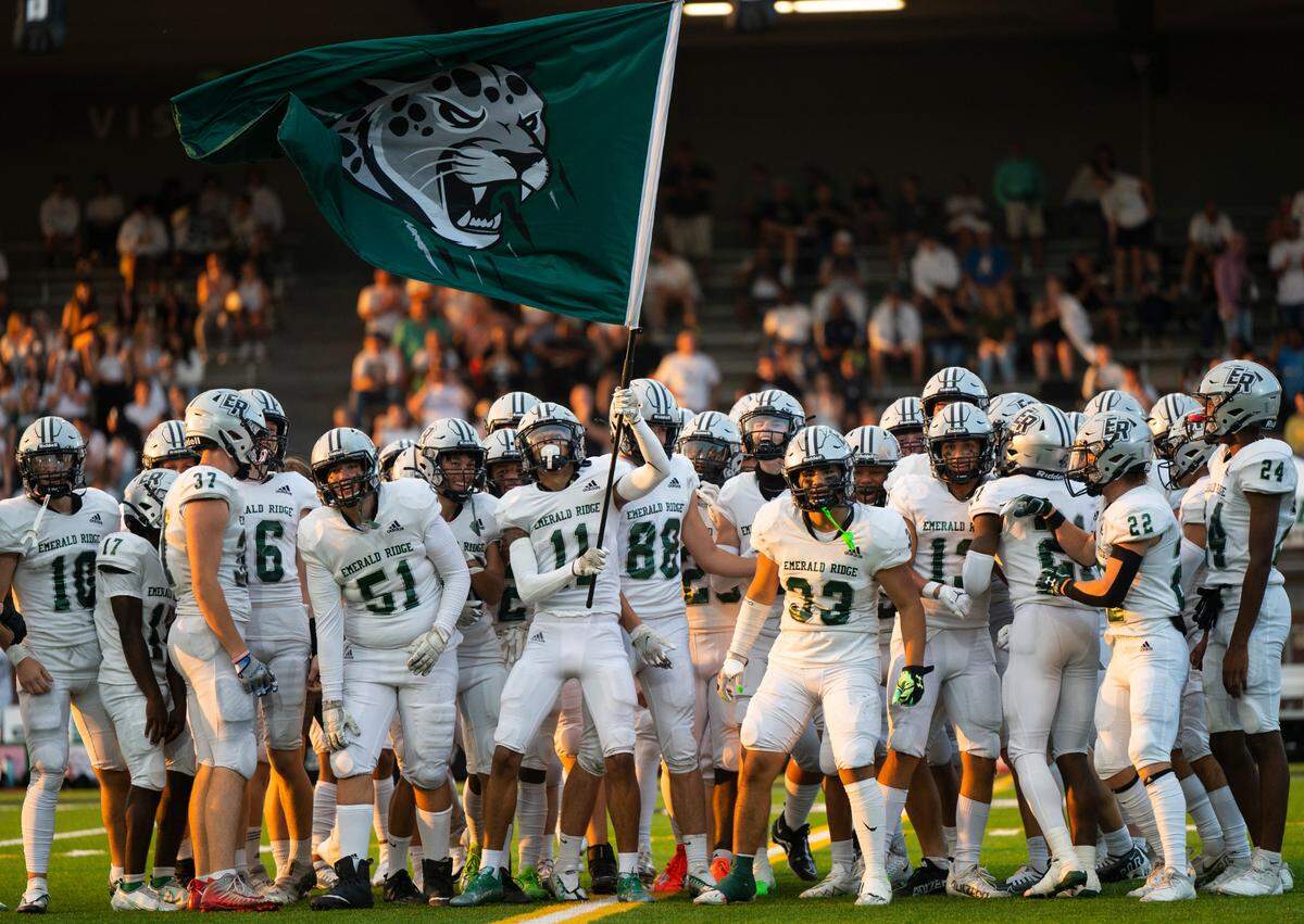 Emerald Ridge wide receiver Brandon Snell (11) waves an Emerald Ridge jaguars flag in the air before the start of the season opener game at Sparks Stadium in Puyallup Wash. on Sept. 2, 2022.