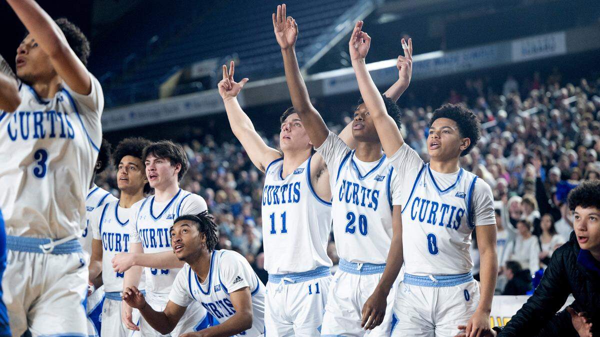 Curtis players watch as Devin Whitten launches a three-point attempt during the Vikings’ state semifinal game against the Federal Way Eagles at the WIAA state basketball tournament in the Tacoma Dome in Tacoma, Washington, on Friday, March 3, 2023. Curtis won the game, 56-43.