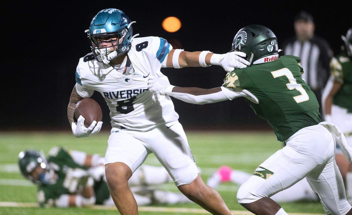 Auburn Riverside running back Thyrou Umi-Tuato’o brushes off Auburn defensive back Luvens Valcin during Friday night’s 3A NPSL championship game at Auburn Memorial Stadium in Auburn, Washington, on Oct. 27, 2023. Auburn Riverside won the game, 41-14.