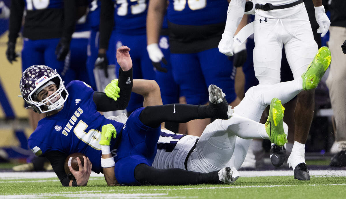 Lake Stevens quarterback Blake Moser (6) is wrapped up by Sumner wide receiver Elias Tulifua (11) during the first quarter of the 4A State Championship game at Husky Stadium, on Saturday, Dec. 6, 2025, in Seattle.