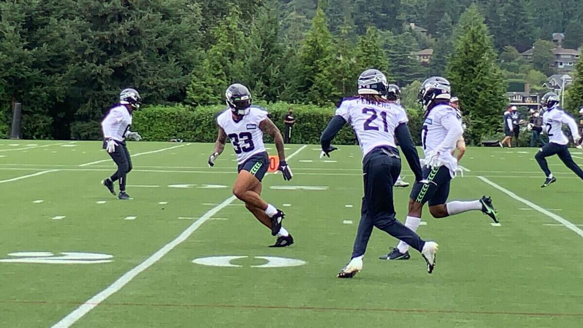 Jamal Adams (33) runs with the fellow starting defensive backs Quandre Diggs (left) and Tre Flowers (21) during drills at the 14th practice of Seahawks training camp Tuesday in Renton. Hours earlier, Adams signed a contract extension making him the NFL’s richest safety.