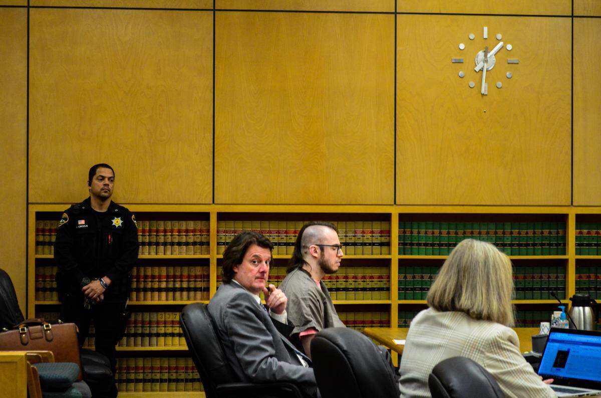 Ezra Fleming Ralston, center, sits with his attorney, Peter Reich, before his sentencing hearing Friday, June 16, 2023 in Pierce County Superior Court. Ralston, 29, was convicted in a jury trial of conspiring with three others to murder his grandparents in 2020 and burn their Vaughn home.