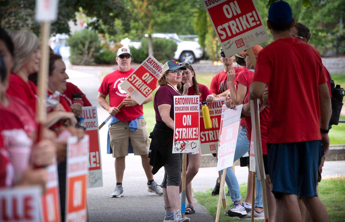 High school English teacher Kirsten Anderson (center) joins fellow teachers outside Eatonville High School on what should have been the first day of classes in the school district in Eatonville, Washington on Wednesday, Sept. 7, 2022, after union and district failed to reach a contract agreement by the Tuesday night deadline.