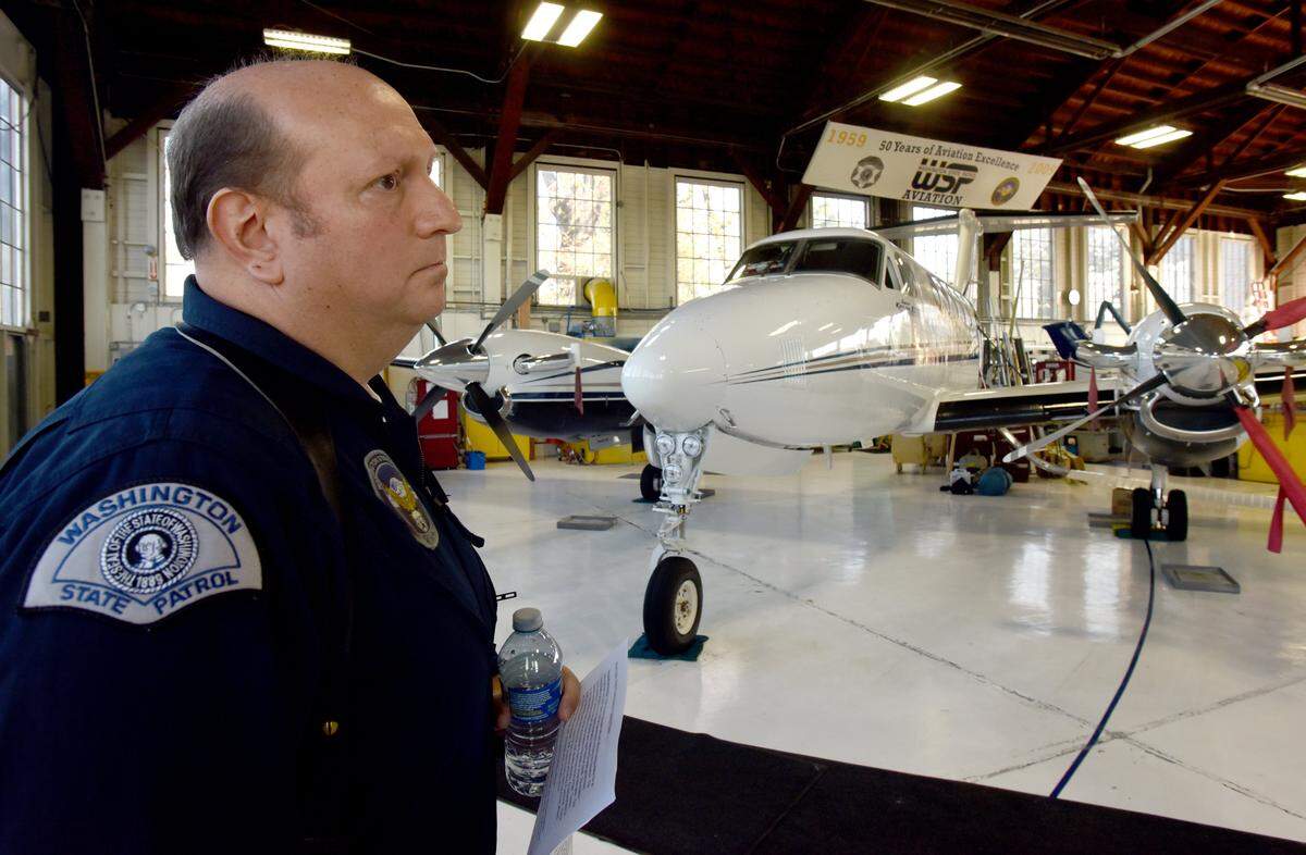 Lt. Jim Nobach stands in the Washington State Patrol's operation's hangar at the Olympia Airport on Nov. 3, 2016 near a King Air plane.