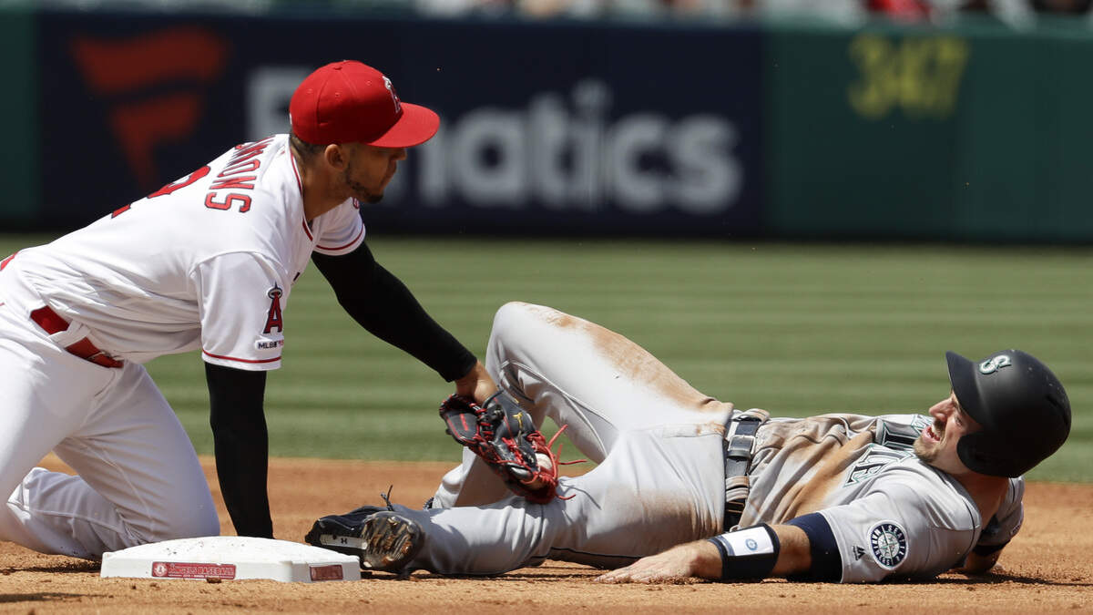 Los Angeles Angels shortstop Andrelton Simmons, left, tags out Seattle Mariners’ Tom Murphy during a rundown during the second inning of a baseball game in Anaheim, Calif., Sunday, April 21, 2019. (AP Photo/Chris Carlson)