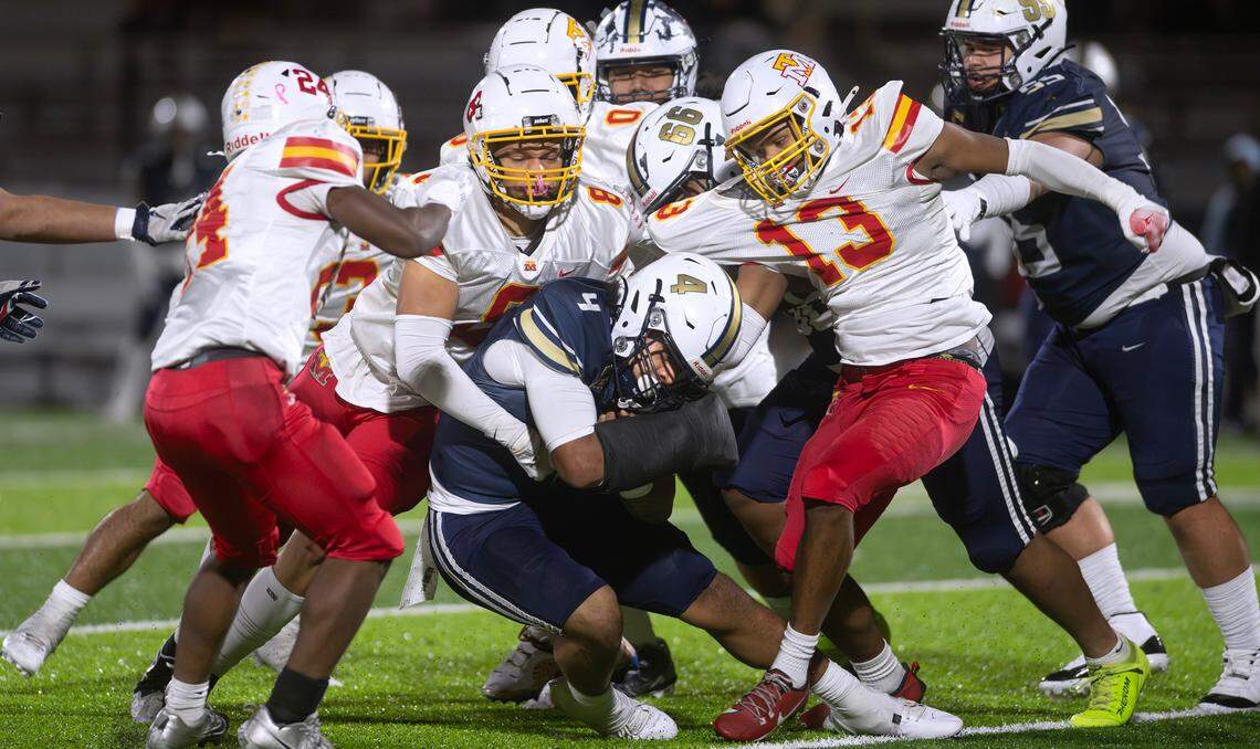 Decatur running back Nehemiah Washington is smothered by Mount Tahoma defenders (from left) Brison Bailey, Shan Jones and Tre Walker during Friday night’s state football playoff game at Federal Way Memorial Stadium in Federal Way, Washington, on Nov. 15, 2024. Mount Tahoma won the game, 23-21.
