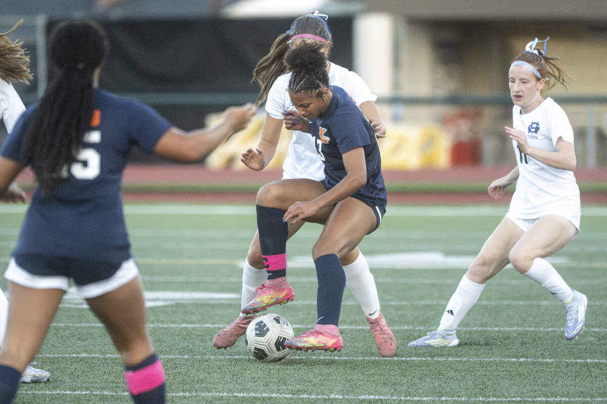 Lakes senior Kendall Griffin (13), center, turns to keep control of the ball as Gig Harbor defenders close in on during a game on Tuesday, Sept. 16, 2025, in Lakewood, Wash.