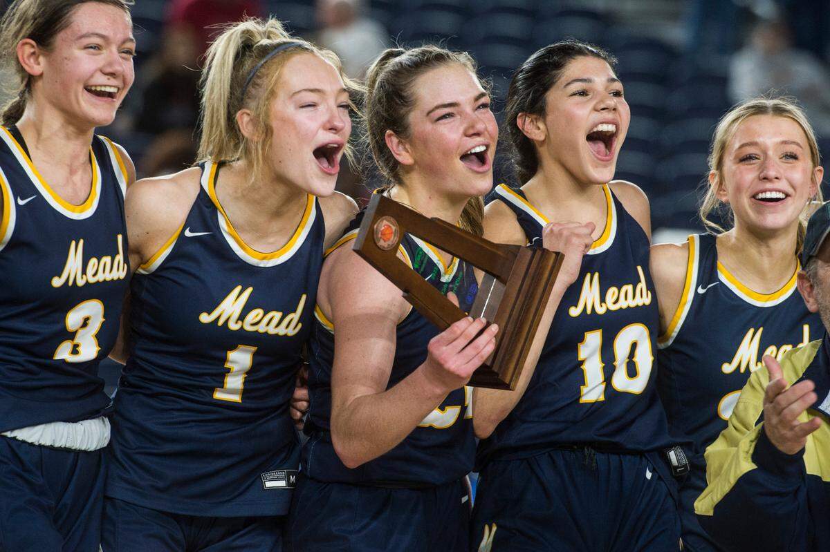 Mead guard Teryn Gardner (24) holds up the trophy following the Panthers’ win over Arlington in the third-fifth place game of the Class 3A girls state basketball tournament on Saturday, March 4, 2023 at the Tacoma Dome in Tacoma, Wash.