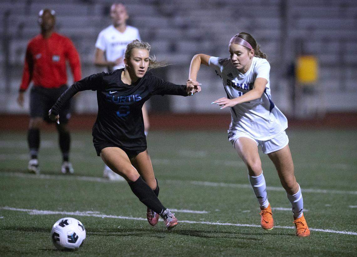 Curtis defender Ivy Korbal (left) battles Sumner midfielder Ava Morton for control of the ball during Monday night’s girls soccer game at Viking Stadium in University Place, Washington, on Oct. 9, 2023. Curtis won the game, 3-2.