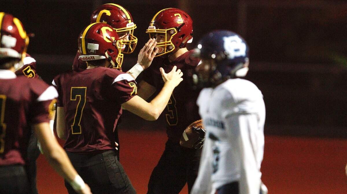 Capital’s Chris Penner celebrates a touchdown with teammates on Friday night. Penner finished with two touchdowns and two interceptions on defense against Gig Harbor.