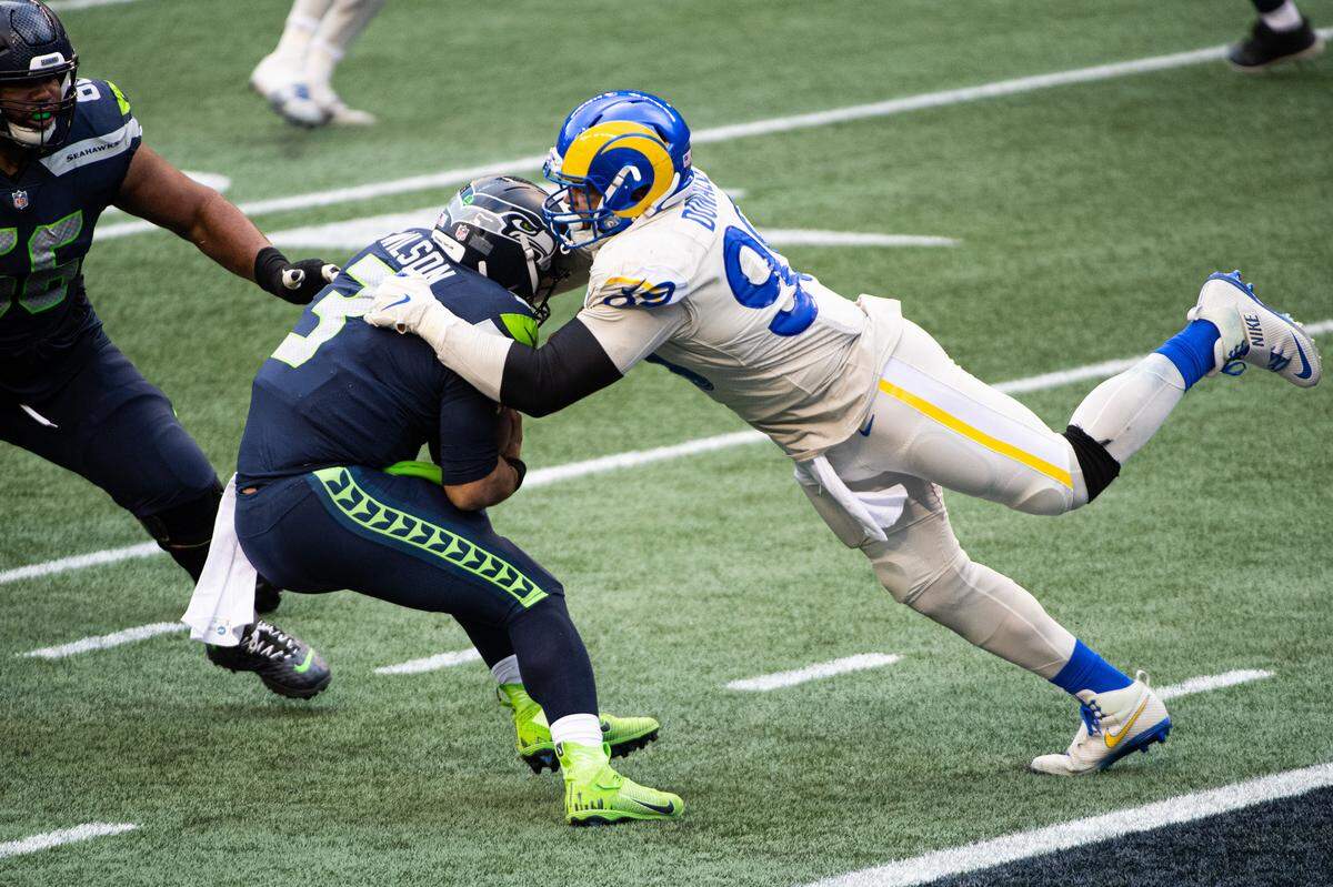 Los Angeles Rams defensive end Aaron Donald sacks Seattle Seahawks quarterback Russell Wilson during the third quarter. The Seattle Seahawks played the Los Angeles Rams in a NFL football game at Lumen Field in Seattle, Wash., on Sunday, Dec. 27, 2020.