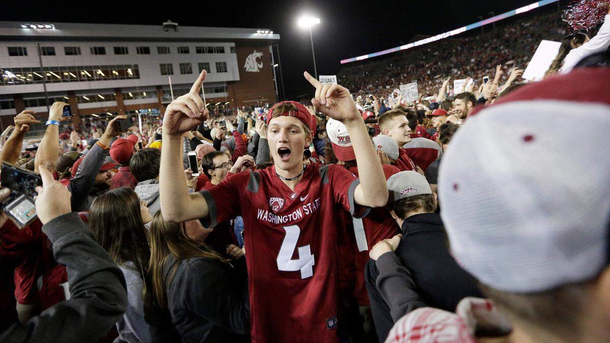 Washington State fans celebrate on the field after Washington State beat Oregon 34-20 in an NCAA college football game in Pullman, Wash., Saturday, Oct. 20, 2018. (AP Photo/Young Kwak)
