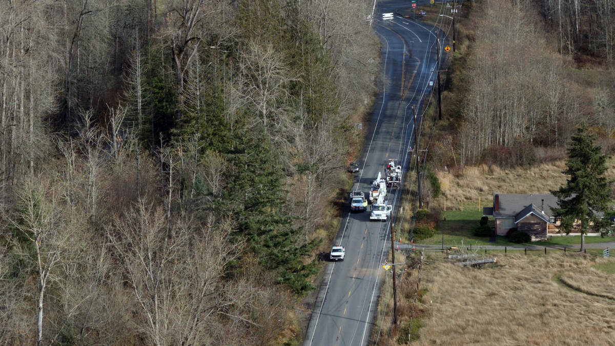 Puget Sound Energy crews close off Highway 165 between Auburn and Buckley after clearing downed trees and fixing power lines on the morning of Wednesday, Nov. 20, 2024.