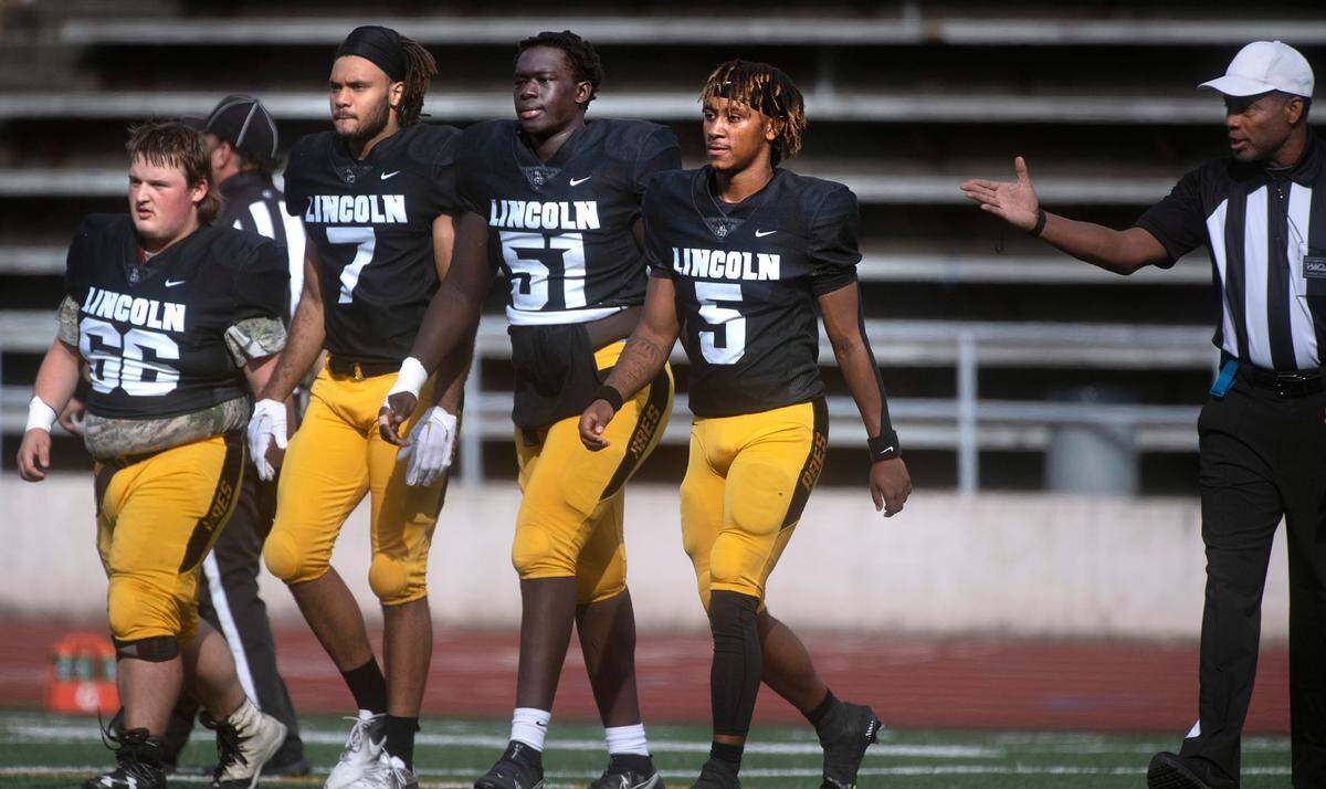Lincoln captains (from left) Jordan Buckner, Stephon Pugh, Daniel Wani and Gabarri Johnson head to midfield for the coin toss before Saturday afternoon’s 4A football game against the Camas Papermakers at Lincoln Bowl in Tacoma, Washington, on Sept. 17, 2022. Lincoln won the game, 42-28.