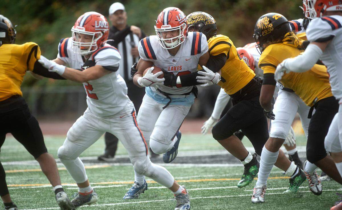 Lakes running back Leo Pulalasi is wrapped up by Lincoln linebacker ZY ZY Sayavong during Saturday afternoon’s football game at Lincoln Bowl in Tacoma, Washington, on Oct. 22, 2022.