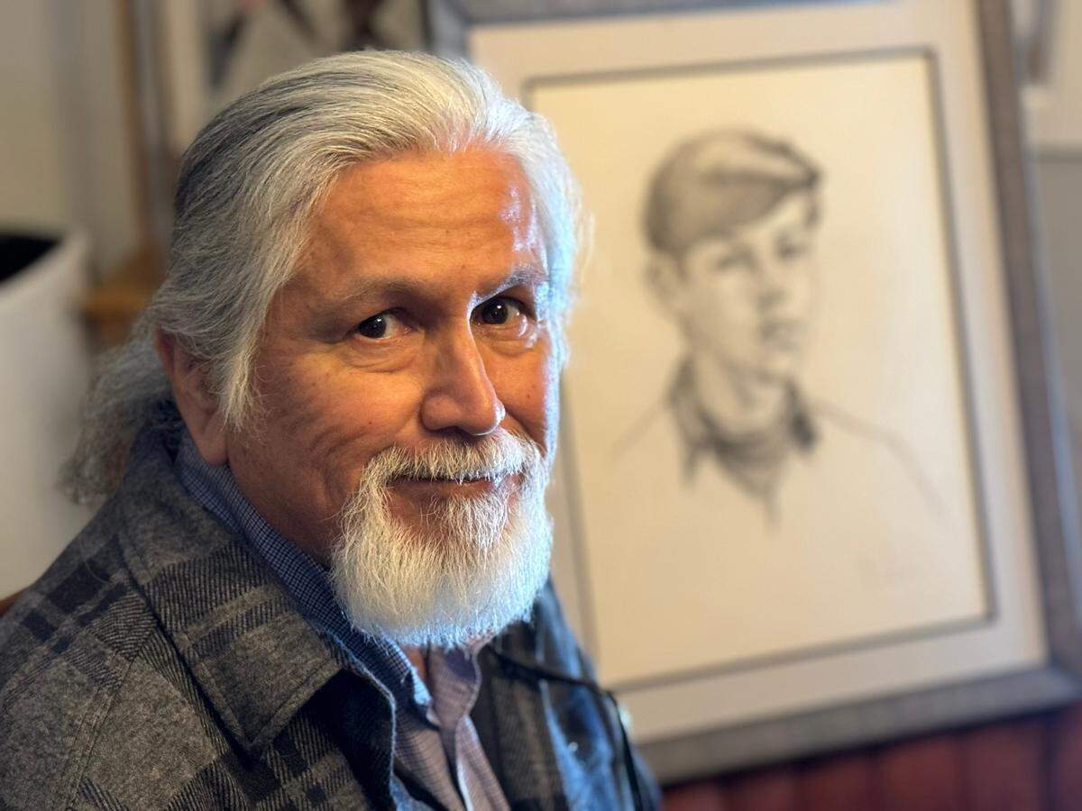Spanaway resident Gabriel Landry with a portrait of himself as a boy, drawn by his cousin Eugene Landry.