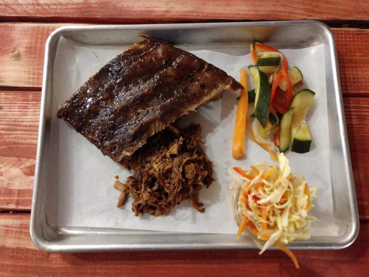 A two-meat tray with ribs and pulled pork, plus slaw and pickles from Brimstone PNW.