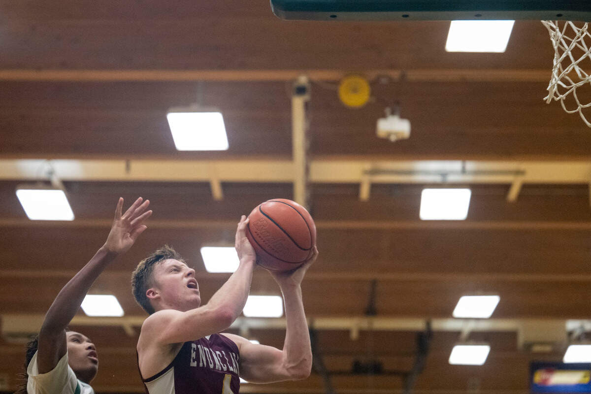 Enumclaw guard Noah Seabrands hangs in the air as he attempts a layup while Foss’s Keshawn Lewis defends during the fourth quarter of 2A SPSL game on Tuesday, Jan. 24, 2023, in Tacoma, Wash.