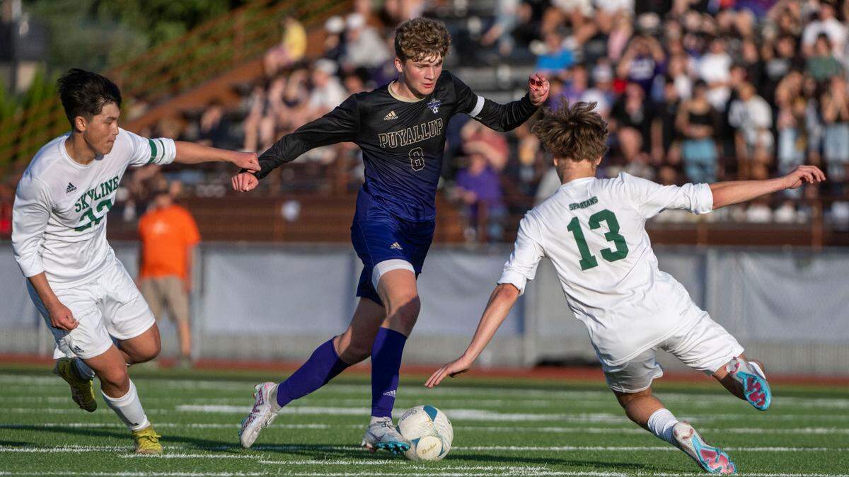 Puyallup’s Dean Williams dribbles through a pair of Skyline defenders during the second half of the Class 4A state championship game on Saturday, May 27, 2023, at Sparks Stadium in Puyallup, Wash.