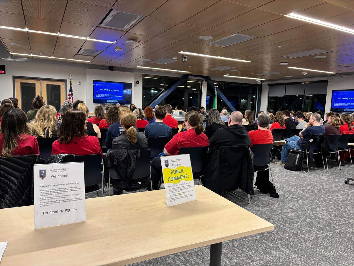 Citizens gather at the Puyallup School District board meeting at the Kessler Center on March 2, 2026. Many wore red, the color of the Puyallup Education Association, and spoke out in public comment to protest the district’s incoming $15 million budget cuts.