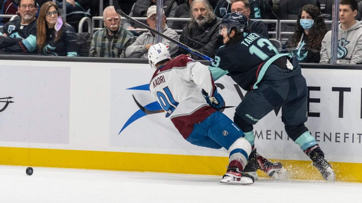 Seattle Kraken left wing Brandon Tanev (13) knocks Colorado Avalanche center Nazem Kadri to the ice during the first period of an NHL hockey game, Friday, Nov. 19, 2021, in Seattle. (AP Photo/Stephen Brashear)