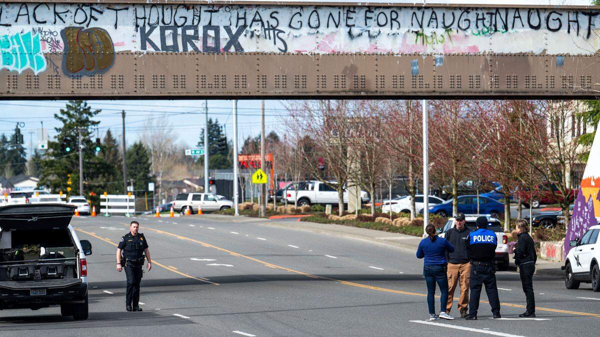 Officers investigate the scene where a man reportedly holding a grenade was shot and killed by Pierce County deputies, on the train tracks near the corner of 112th Street East and Portland Avenue on March 24, 2023. No officers where injured.