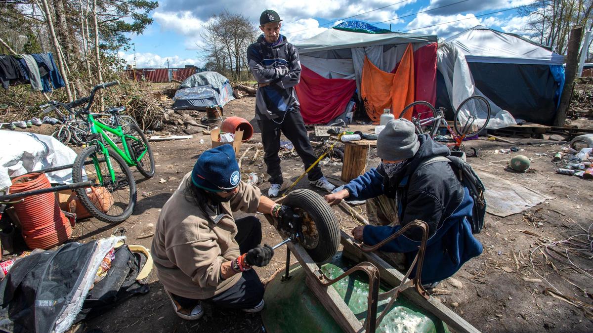 Jose Miguel Manitas, left, and Javier Luna Sipiriano, two men experiencing homelessness, work to repair a wheelbarrow as another man watches on Saturday, April 10, 2021. All are residents of an encampment on East 72nd and F streets in Tacoma that the city plans to clear next Tuesday. Manitas says he will abide by the evacuation notice because he has “no choice” and will “ask the Lord” for guidance as to where he should move next.