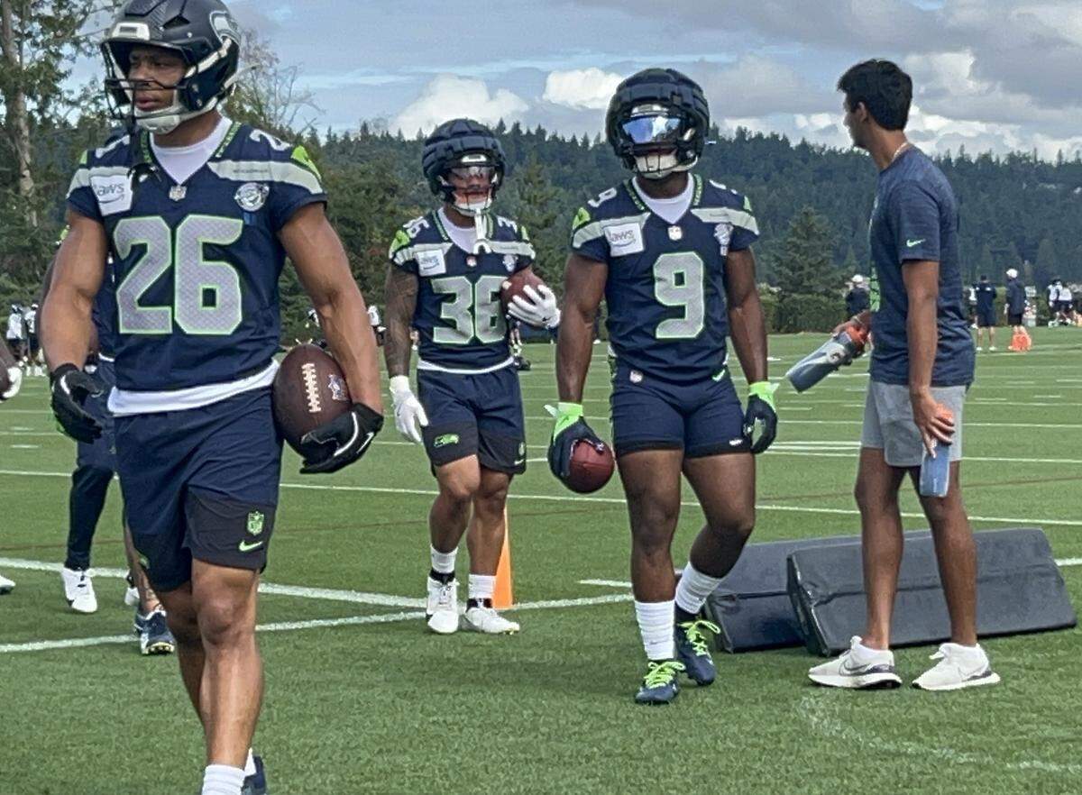 Kenneth Walker (9) full go with fellow running backs Zach Charbonnet (26) and George Holani, the standout rushers in each of the first two preseason games, on the 20th practice of the Seahawks’ preseason Sunday, Aug. 17, 2025, at the Virginia Mason Athletic Center in Renton.