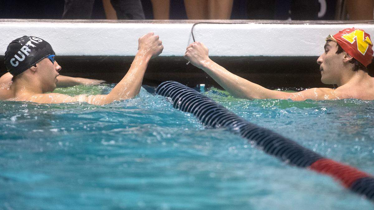 Curtis’ Tolu Young (left) is congratulated by Newport’s Liam Campbell after Young won the 50-yard freestyle state title during the WIAA 4A Boys State Swimming and Diving Championships at the King County Aquatic Center in Federal Way, Washington, on Saturday, Feb. 18, 2023. Campbell flipped the script later in the morning, edging Young for the title in the 100-yard freestyle.
