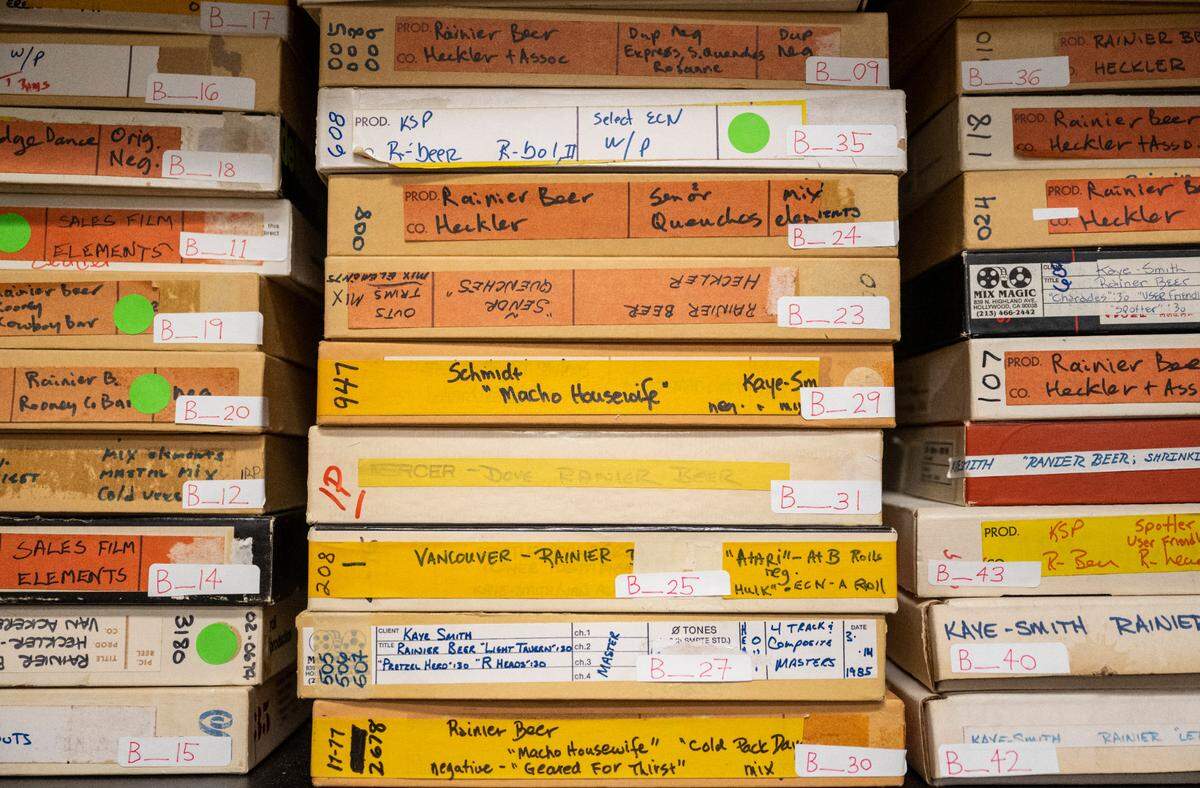 Iconic Rainier beer television commercials from the 1970’s and 1980’s lie on shelves in filmmaker and director, Isaac Olsen’s, studio in Tacoma, Wash. on Sept. 20, 2022. The Washington State Historical Society lent Olsen the original film from the making of the commercials.