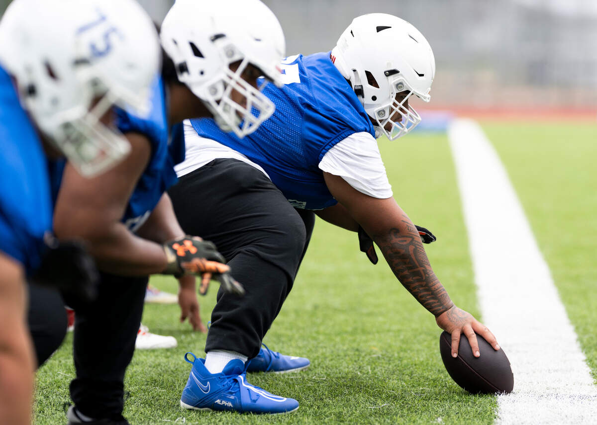 Graham-Kapowsin offensive lineman Kaleb Leatiga snaps the ball gaduring a football practice at Graham-Kapowsin High School, on Thursday, Aug. 22, 2024, in Graham, Wash.