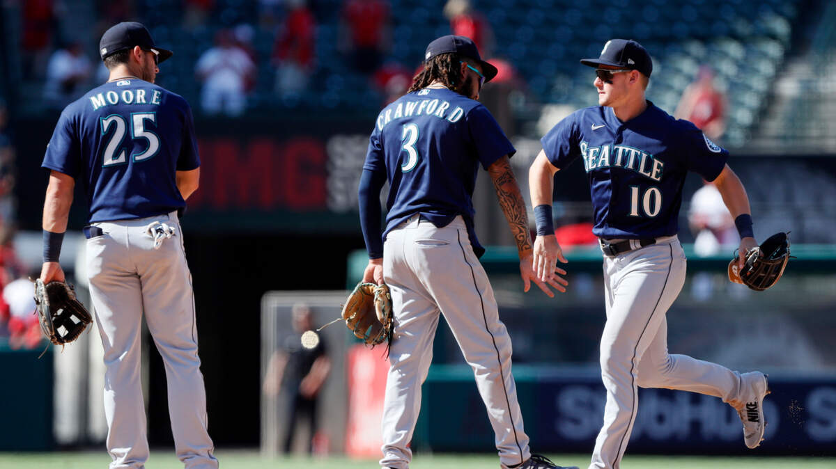Seattle Mariners’ Dylan Moore, left, J.P. Crawford and Jarred Kelenic, right, celebrate the team’s 7-4 win in a baseball game against the Los Angeles Angels in Anaheim, Calif., Sunday, July 18, 2021. (AP Photo/Alex Gallardo)