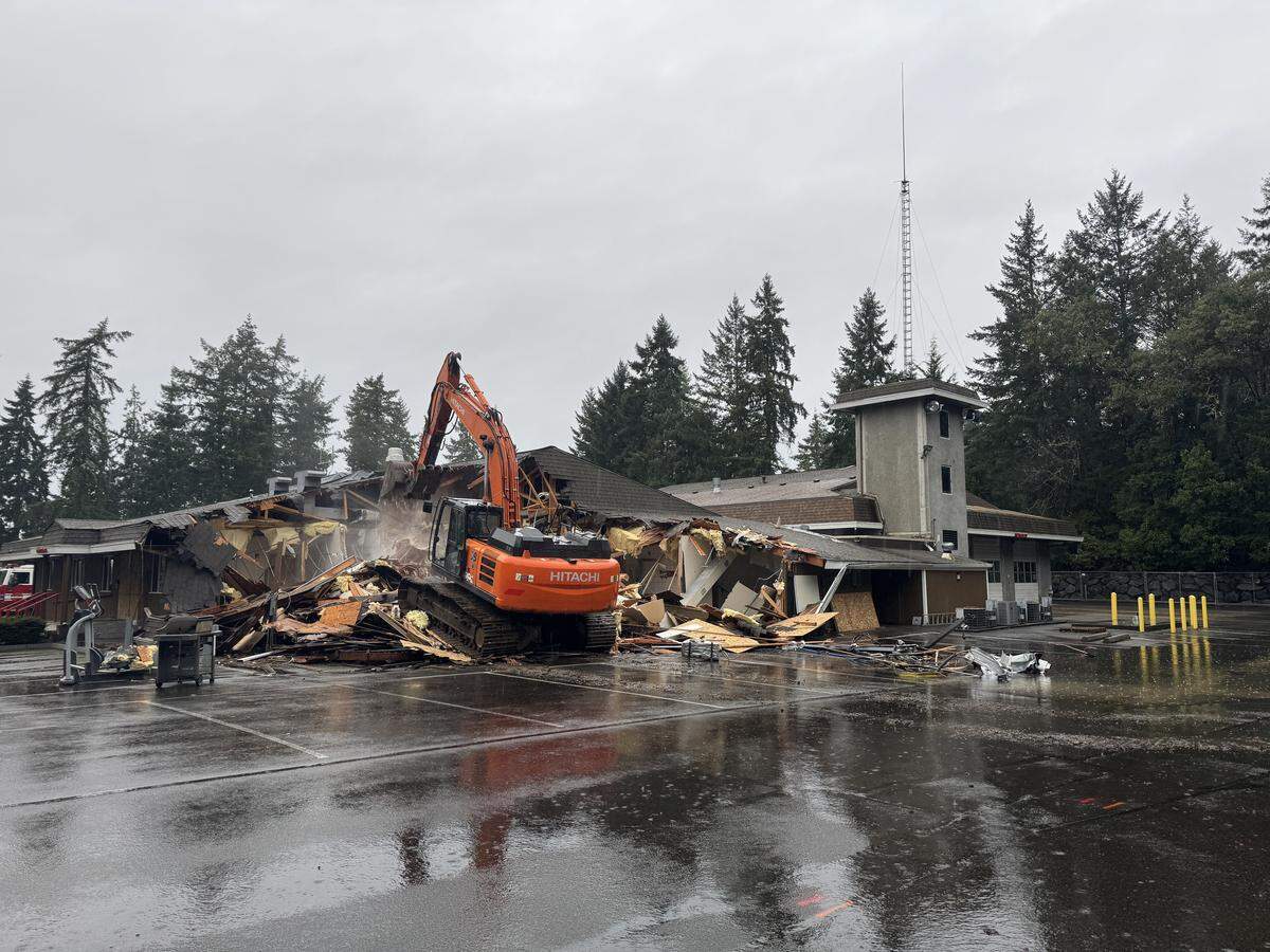 An excavator tears into Gig Harbor Fire & Medic One Station 51 in Gig Harbor, Wash., Monday, Feb. 2, 2026, starting the process of demolition as the fire department prepares for a full rebuild of the facility first built in 1979.