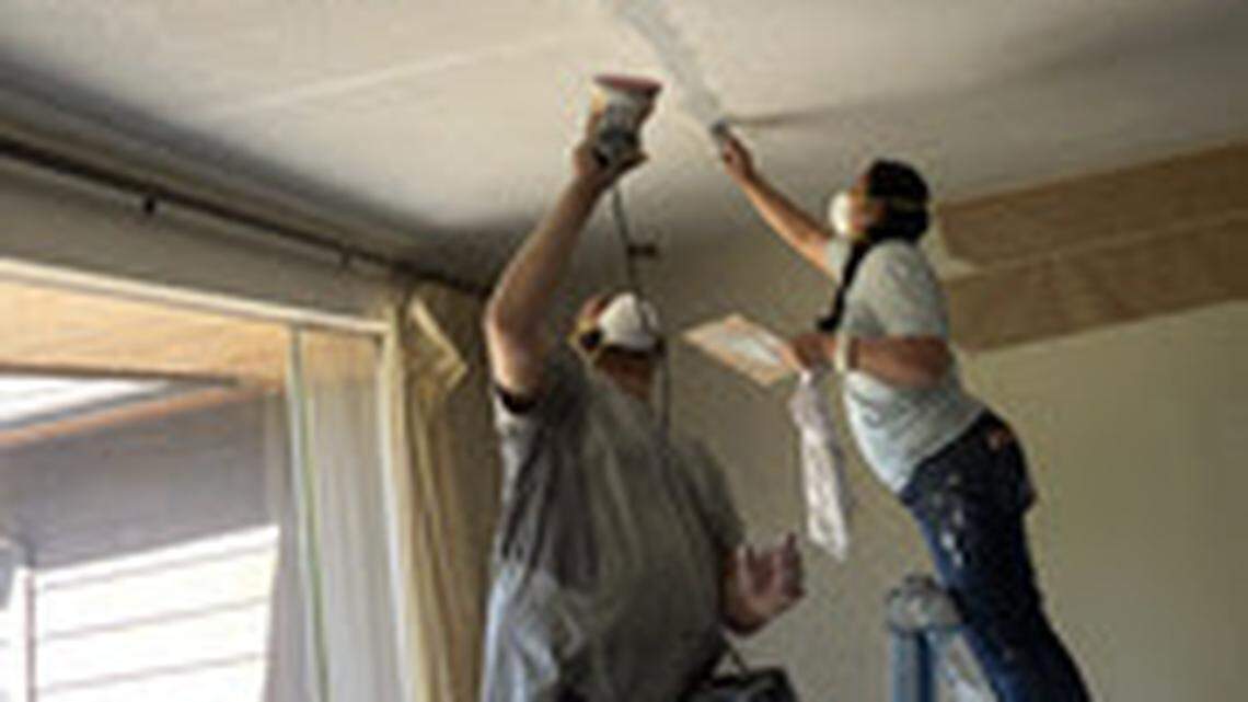 Workers hired last summer to remove a popcorn ceiling that contained asbestos in an Everett home wore N95 masks that don’t protect against the toxic mineral fiber, according to the Washington State Department of Labor & Industries, which provided this photograph -- taken by the homeowners -- in a news release.