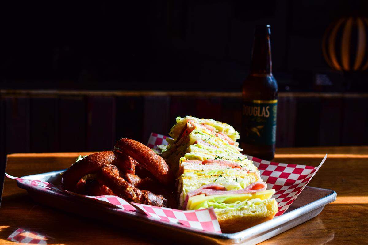 The New Frontier Lounge is a restaurant, bar and music venue in Tacoma’s Dome District. The kitchen serves fun bar food, including a massive club sandwich and hand-dipped onion rings.