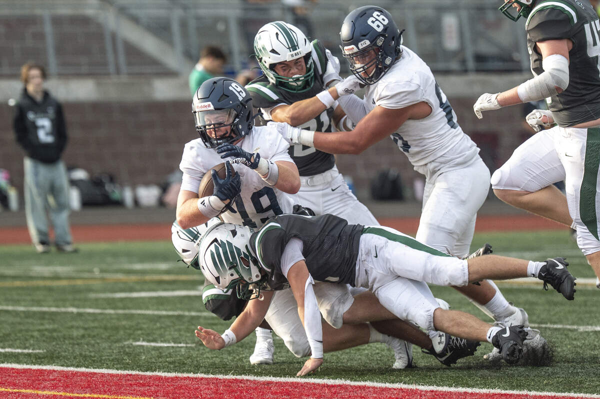 Gig Harbor running back Wilson West (19), left, dives to land in the end zone for a touchdown against Peninsula during the Fish Bowl matchup on Saturday, Sept. 6, 2025, at Mount Tahoma High School in Tacoma, Wash.